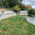 How Natural Stone Retaining Walls Protect Pools on Sloped Properties